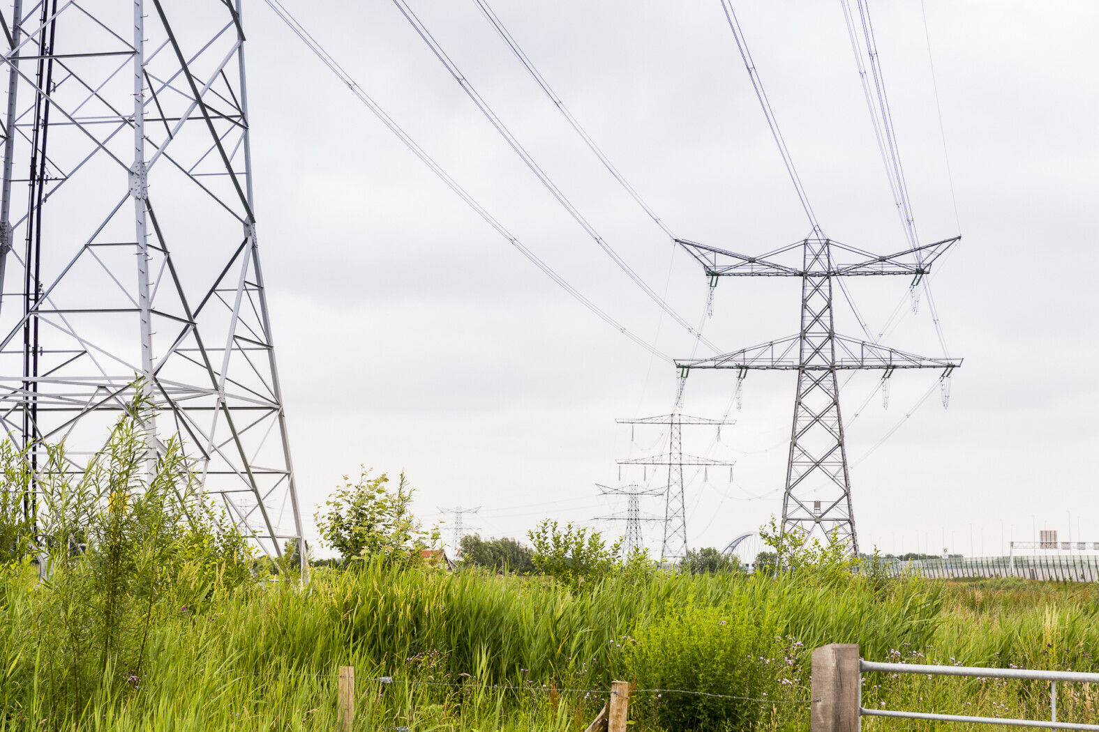 Hoogspanningsmasten door groen landschap als onderdeel van energie-infrastructuur
